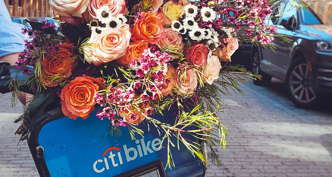 A vibrant bouquet of roses and seasonal blooms carried on a Citi Bike in New York City