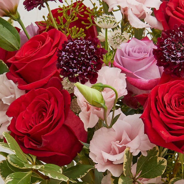 Bouquet of Pink Lisianthus Deep Purple Roses Freedom Roses and Carnations with Pittosporums and Seeded Eucalyptus greeneries.
